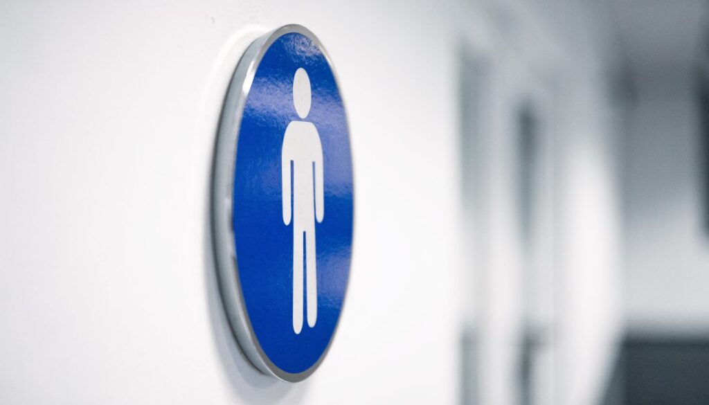 Panneau de sécurité rond à fond bleu et pictogramme blanc fixé sur un mur clair, forme et couleur de la famille obligation